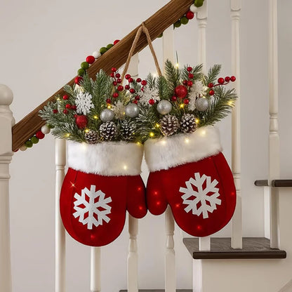 Glove-shaped red mitten garland with white fur cuff, pine boughs, berries, pinecones and lights on a staircase railing.